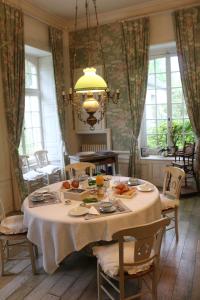 una sala da pranzo con un tavolo con del cibo sopra di Château de Grandval - Sainte Mere Eglise a Neuville-au-Plain