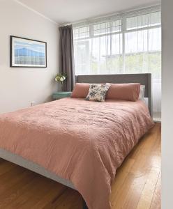 a bedroom with a large bed with a orange bedspread at Home on The Grange in Mt Eden in Auckland