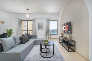 a living room with a couch and a table at JBR Beach Bliss - One & Three Bedroom Luxury Apartments by Sojo Stay in Dubai