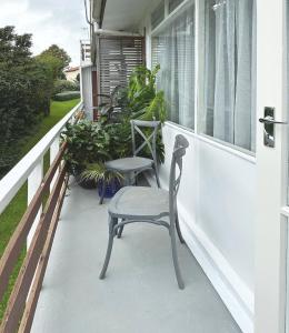um alpendre com 2 cadeiras e uma janela em Home on The Grange in Mt Eden em Auckland