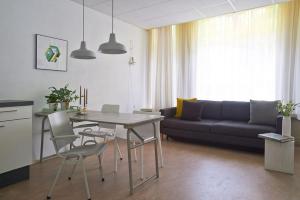 een woonkamer met een tafel en een bank bij Kranenbergh Boutique Apartments in Bergen