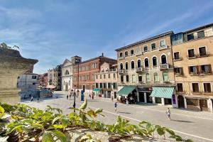 a city street with buildings and people walking on the street at City Apartments Biennale in Venice
