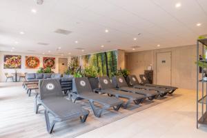 a waiting room with chairs and paintings on the wall at Fletcher Familiehotel De Hunzebergen in Exloo