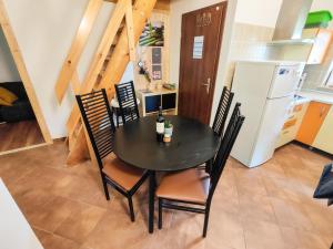 a dining room with a table and chairs and a refrigerator at Silent Orchard in Naklo