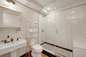 a white bathroom with a toilet and a sink at Home NYC in New York