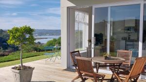 a patio with a table and chairs on a balcony at Knysna Private Estate Lagoon - Garden Apartments- Secure Estate in Knysna