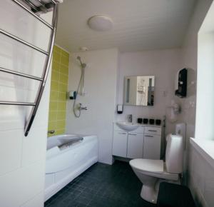 a bathroom with a toilet and a tub and a sink at Bed and Breakfast Artjärvi in Artjärvi