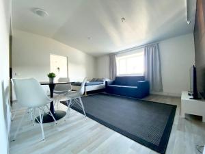 a living room with a blue couch and a table and chairs at City Home Finland Penthouse – SAUNA & Best Location in Tampere