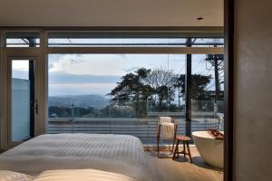een slaapkamer met een bad, een bed en een raam bij Daybreak in Jiufen