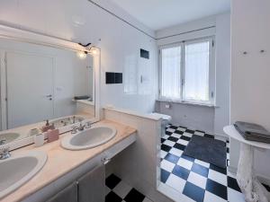 ポルトフェッラーイオにあるA casa di Enrico B&Bのバスルーム(洗面台2台、チェッカー付)