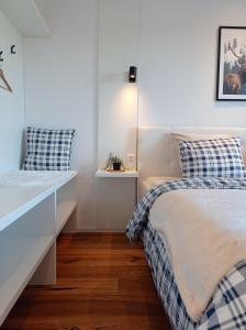 a white bedroom with a bed and a lamp at Jelení apartmán Rychlebské stezky in Černá Voda