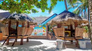 two chairs and umbrellas in front of a house at North Ville Beach Resort powered by Cocotel in Bantayan Island