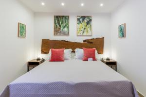1 dormitorio con 1 cama blanca grande con almohadas rojas en Mama Tita Rooms and Breakfast en Palermo