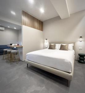 ein Schlafzimmer mit einem großen weißen Bett und einem Tisch in der Unterkunft 3L Luxury Rooms in La Spezia