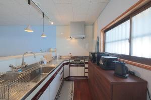 a kitchen with a sink and a counter top at guesthouse minkä in Amami