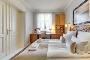 a bedroom with a large white bed with towels on it at Downtown Apartments Sopot Jagiełły in Sopot