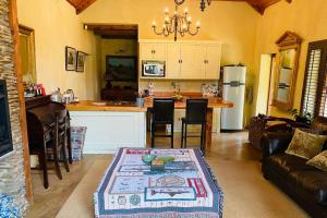 uma cozinha e sala de estar com uma mesa e um balcão em Stonehaven Cottage em Machadodorp