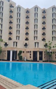 an empty swimming pool in front of a large building at Sigma Base Apartments in Lagos
