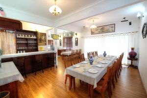 a dining room with a long table and a bar at PLAY at Arabella Tudor House in Tanah Rata