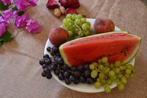 a plate of fruit with a slice of watermelon and grapes at Saroko Studio in Corfu