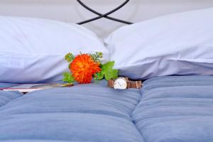 a watch and a flower on top of a bed at Saroko Studio in Corfu +12 photos