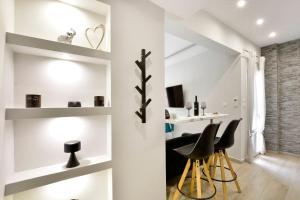 a room with white walls and black chairs and shelves at Saroko Studio in Corfu