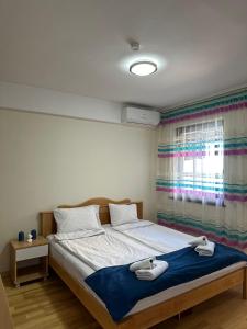 a bedroom with a bed with two towels on it at Park Diamond Apartments in Ohrid