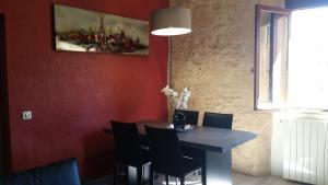 a dining room table with chairs and a painting on the wall at PETITS ANGES in Sarlat-la-Canéda +3 photos