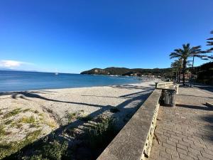 a bench on a beach next to the water at Le vasche - by the sea - nice apartment in Cavo