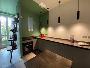 a kitchen with green walls and a counter top at Da Amélie - Casa Ludovica nel cuore della Gran Madre a Torino in Turin