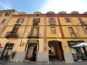 a yellow building with an archway in a city at Da Amélie - Casa Ludovica nel cuore della Gran Madre a Torino in Turin