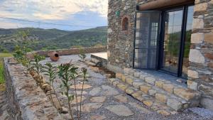 ein Steinhaus mit einer Steinmauer und einem Fenster in der Unterkunft Peaceful Stone House with Nature View in Karaburun in Izmir