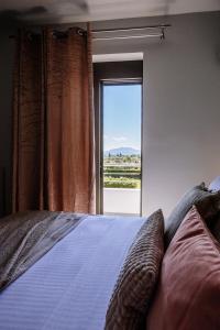 a bedroom with a bed with a large window at Palaz Villa in Ayios Kirikos