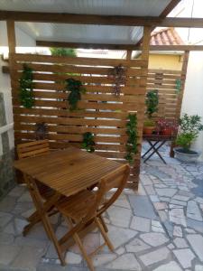 Une table et des chaises en bois sont disponibles sur la terrasse. dans l'établissement Abrigo dos Coelhos, à Carcavelos