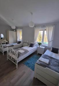 uma sala de estar com três camas e uma mesa em Zielono Mi - Dom Gościnny w Łapalicach em Łapalice