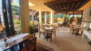 a restaurant with wooden tables and chairs and windows at Hotel Villa Bora in Sunny Beach