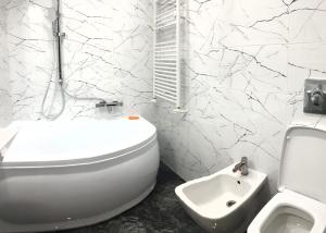 a white bathroom with a toilet and a sink at Garsoniera in Dorohoi