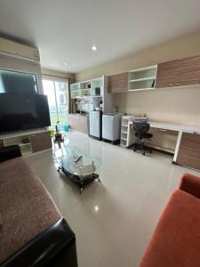 a living room with a glass coffee table and a tv at The Ozone Krabi Condotel in Krabi