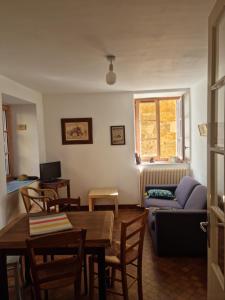 ein Wohnzimmer mit einem Tisch und einem Sofa in der Unterkunft Maisonnette au Cœur de la cité Médiévale. in Sarlat-la-Canéda