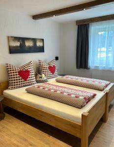 two beds in a room with hearts on the wall at Ferienwohnungen LODGE-B in Weissenbach am Lech