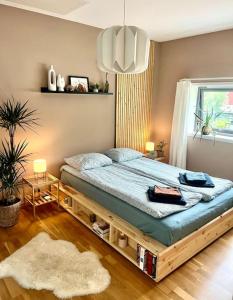 a bedroom with a bed with a wooden frame at Top floor apartment with mountain view, terrace 22sqm, free parking in Bergen