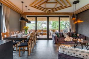 - une salle à manger avec une table, des chaises et un canapé dans l'établissement Góralska Domina Ville Premium, à Zakopane