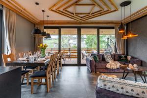 a dining room with a table and chairs and a couch at Góralska Domina Ville Premium in Zakopane