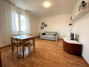 a living room with a table and a couch at Genova 9 in Grado