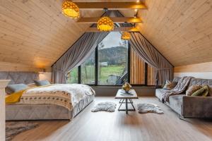 sypialnia z dużym łóżkiem i kanapą w obiekcie Góralska Domina Ville Premium w Zakopanem