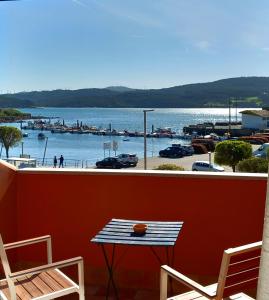 a table and chairs on a balcony with a view of a harbor at Hotel Puerto Arnela in Camariñas