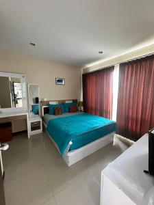 um quarto com uma cama com lençóis azuis e uma janela em The Ozone Krabi Condotel em Krabi