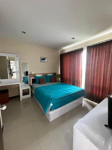 a bedroom with a bed with blue sheets and a window at The Ozone Krabi Condotel in Krabi