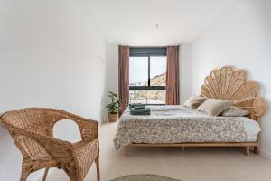 a bedroom with a bed and a chair and a window at Holiday apartment Middle Views in Fuengirola