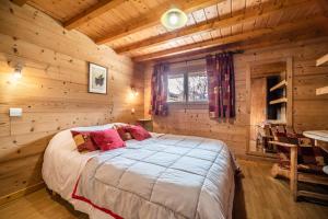 a bedroom with a bed in a log cabin at Chalet Nid Zut in Châtel